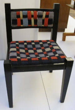 Tessuti di Gunta Stölzl su una sedia di Marcel Breuer (1922): Sedia imbottita a scacchiera con gambe in legno scuro. 