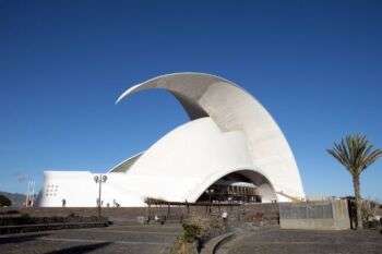 O Auditório de Tenerife "Adán Martín". Foto que retrata a estrutura em forma de cúpula, feita de material branco opaco e a peculiaridade da forma que lembra uma concha, com a ponta voltada para fora.